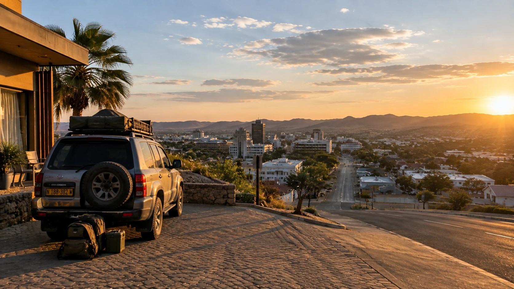 A 4x4 with a rooftop tent parked above Windhoek at sunset, packed and ready for a Namibia self-drive trip
